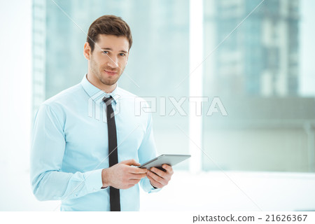 Young businessman in office with big window Young businessman in office with big window 21626367