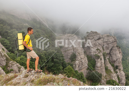 Hiker with backpacker in the foggy mountains Hiker with backpacker in the foggy mountains 21630022
