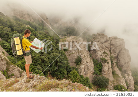 Hiker researches a way using paper map Hiker researches a way using paper map 21630023