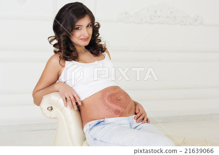 Pregnant woman with henna tattoo on her belly  21639066