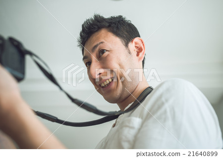 Portrait of a smiling man holding a camera Portrait of a smiling man holding a camera 21640899