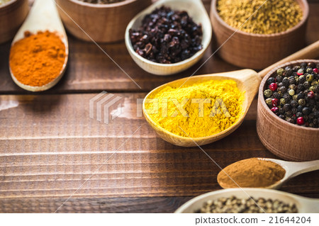 colorful spices in wooden spoons and bowls 21644204