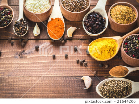 colorful spices in wooden spoons and bowls 21644206