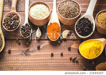 colorful spices in wooden spoons and bowls 21644207