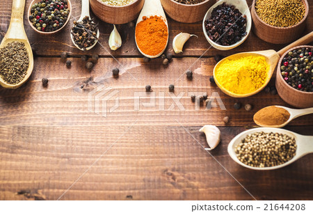 colorful spices in wooden spoons and bowls 21644208