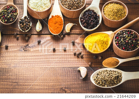 colorful spices in wooden spoons and bowls 21644209