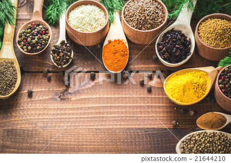 colorful spices in wooden spoons and bowls 21644210