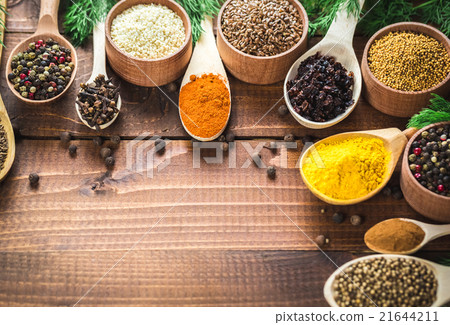 colorful spices in wooden spoons and bowls 21644211
