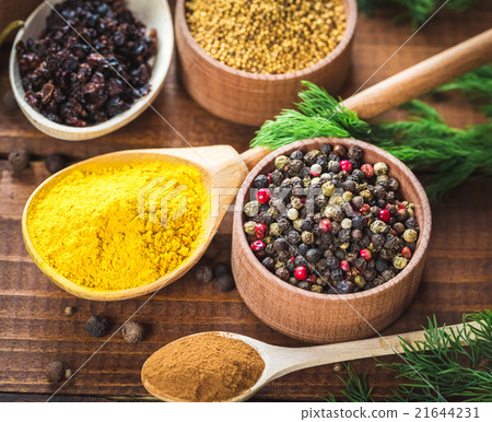 colorful spices in wooden spoons and bowls 21644231