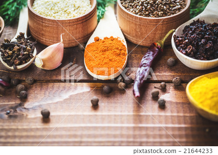 colorful spices in wooden spoons and bowls 21644233
