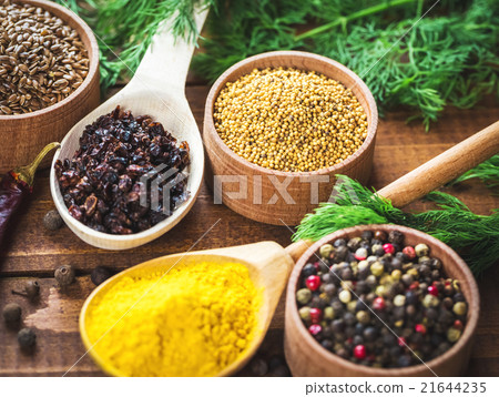 colorful spices in wooden spoons and bowls 21644235