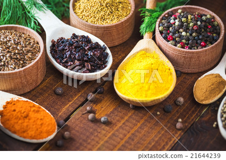 colorful spices in wooden spoons and bowls 21644239