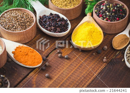 colorful spices in wooden spoons and bowls 21644241
