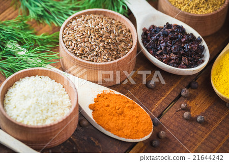 colorful spices in wooden spoons and bowls 21644242
