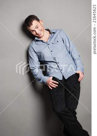 Smiling man casually leaning against the wall 21645625