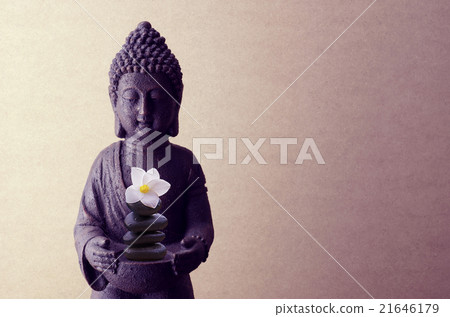 Buddha statue on a beige background with flower 21646179