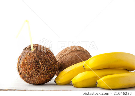 Coconut with straw and bananas on the white table Coconut with straw and bananas on the white table 21646283