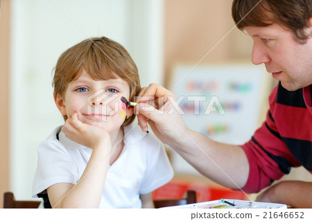 Dad painting flag on face of little kid for 21646652
