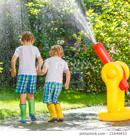 Two little kids playing with garden hose and water 21646653