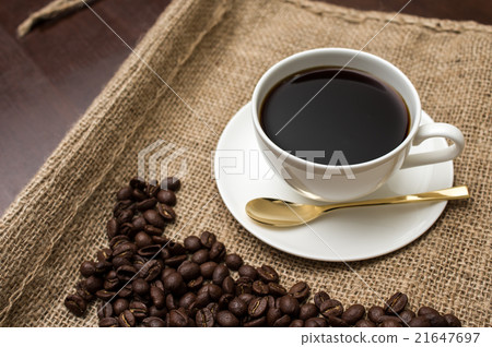 Coffee beans on a hemp bag and a cup of coffee gold spoon 21647697
