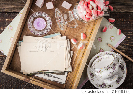 Tea things with sweets and postcards on the tray Tea things with sweets and postcards on the tray 21648334