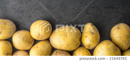 Raw potatoes on the dark stone table wide screen 21649765