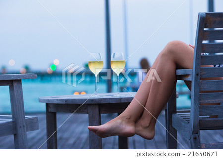 Young woman with a glass of white wine at evening 21650671
