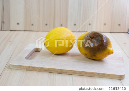 Fresh and rotten lemon put on chopping block 21652410