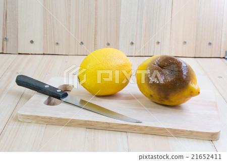 Fresh and rotten lemon put on chopping block Fresh and rotten lemon put on chopping block 21652411