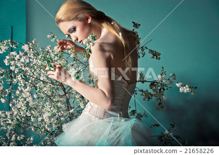 Bride in wedding dress behind bush with flowers 21658226