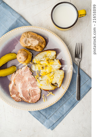 Baked potatoes with meat and pickles on the plate 21658899