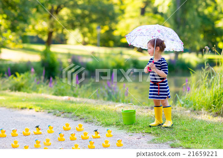 Little girl playing in forest and wearing boots Little girl playing in forest and wearing boots 21659221
