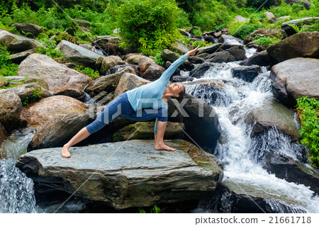 Woman practices yoga asana Utthita Parsvakonasana Woman practices yoga asana Utthita Parsvakonasana 21661718
