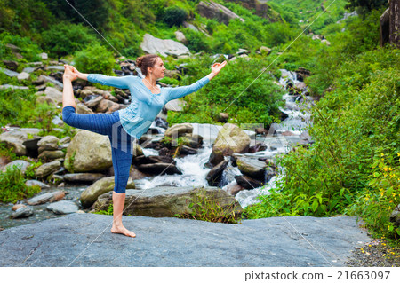 Woman doing yoga asana outdoors at waterfall Woman doing yoga asana outdoors at waterfall 21663097