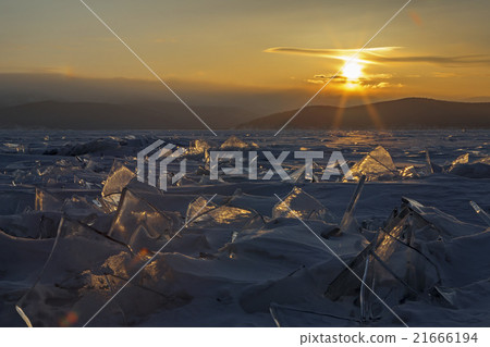 Transparent pieces of ice and the rising sun. Transparent pieces of ice and the rising sun. 21666194