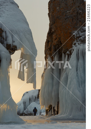Huge icicles on rocks at sunrise. Huge icicles on rocks at sunrise. 21666223