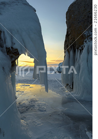 Huge icicles on rocks at sunrise. Huge icicles on rocks at sunrise. 21666230