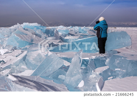 Clumps of blue ice on the snow. 21666245