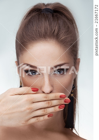 Portrait of beautiful woman with hand on lips over Portrait of beautiful woman with hand on lips over 21667172