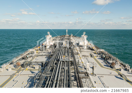 Tanker is proceeding in blue sea under cloudy sky. 21667985