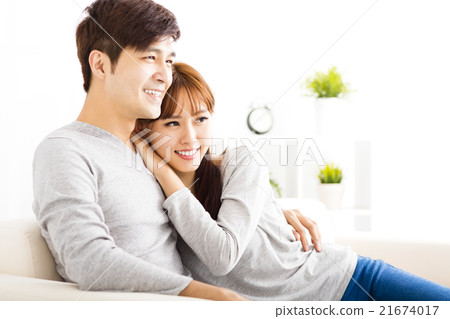 sweet young couple sitting in sofa 21674017