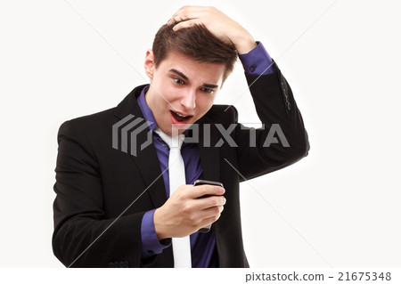 Young businessman amazedly looking at the phone  21675348