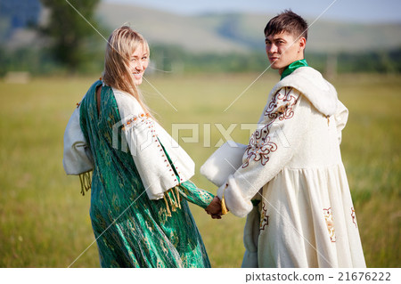 Couple in ethnic costumes hold hands turned back 21676222