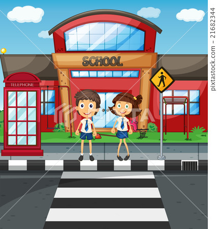 Two students crossing road in front of school 21682344