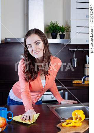 Attractive woman cleaning the counter in the kitchen 21682474