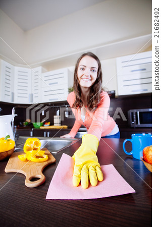 Attractive woman cleaning the counter in the kitchen 21682492
