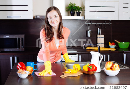 Attractive woman cleaning the counter in the kitchen 21682497