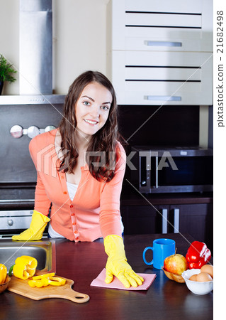 Attractive woman cleaning the counter in the kitchen 21682498