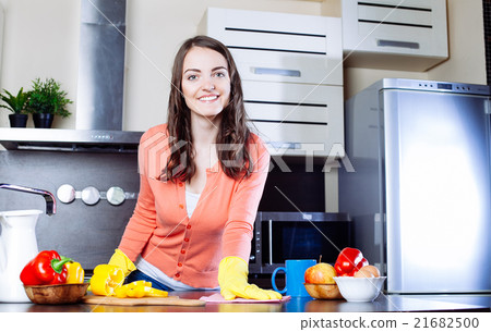 Attractive woman cleaning the counter in the kitchen 21682500