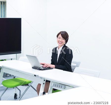 進入個人計算機的女商人在會議室 進入個人計算機的女商人在會議室 21687228